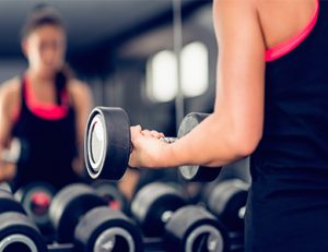 Woman exercising with dumbbell in health club